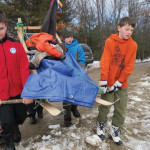A group of scouts carry their sled filled with appropriate gear